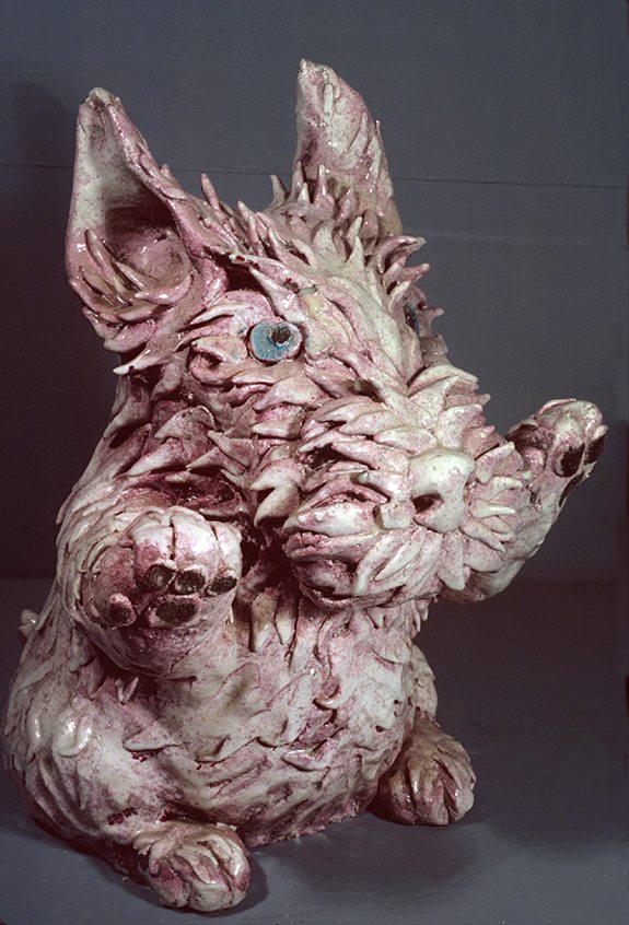 Ceramic sculpture by David Gilhooly titled Pink Terrier (1968). Pink dog with blue eyes sitting on hind legs.