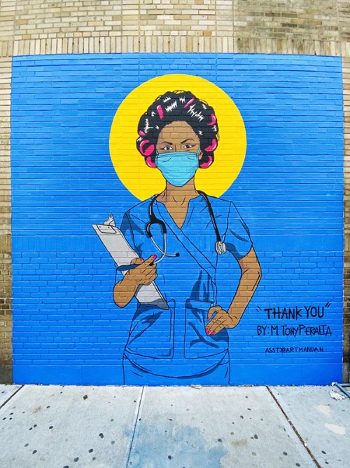 Mural by M. Tony Peralta titled Thank You (Nurse with Rollers) (2020). Woman wearing pink hair rollers, a blue surgical mask, and blue scrubs with a yellow circle behind her head against a blue background.