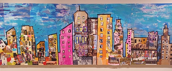 Collaborative collage mural by sixteen art educators and Alice Mizrachi titled Minneapolis Skyline (2024). Cityscape of the Minneapolis skyline with colorful buildings and blue sky.