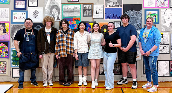 Frank Juárez (left) and the NHS art department in front of its 200-plus student art display during the 2024 EXPO community event at Sheboygan North High School.