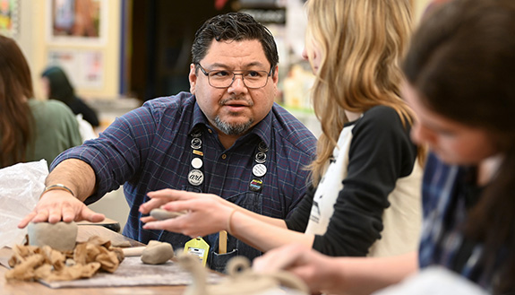 Frank provides feedback to art students during a ceramic project. Photo courtesy of the Sheboygan Area School District.